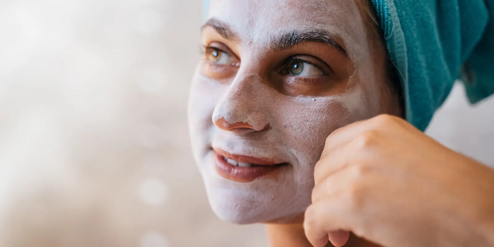 Vrouw smeert dagcrème op haar gezicht na gebruik van zacht water uit een waterontharder, ter verlichting van huidklachten